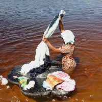 A woman washes clothes in the Alegre river, Brazil. © Gianluca Figliola Fantini | Shutterstock 