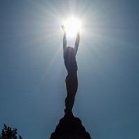 © dreamstime | Backlit statue of Icarus holding the sun 