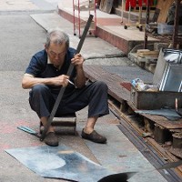 An old man crafts an object from metal in the streets of Hong Kong © Alexandre Tziripouloff | Dreamstime.com 